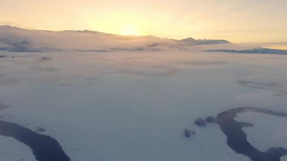Flying over winter landscape in Wyoming moving over winding river alt