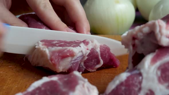 Knife in Female's Hand Cut Raw Pork Meat