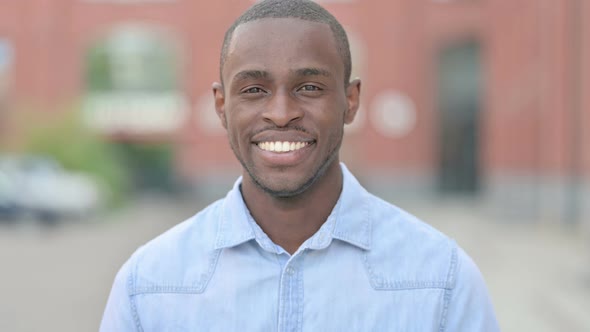 Outdoor Portrait of Young African Man Saying Yes By Shaking Head alt