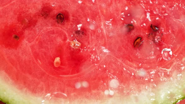 Super Slow Motion Macro Shot of Falling and Splashing Water Drops on Fresh Watermelon at 1000Fps alt