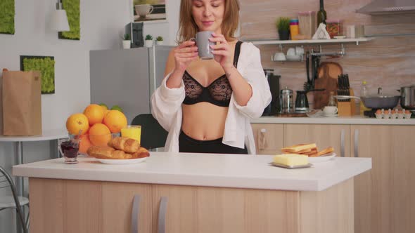 Woman in Lingerie Drinking Coffee alt