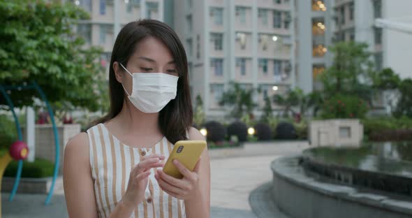 Woman wear face mask and use of mobile phone at outdoor