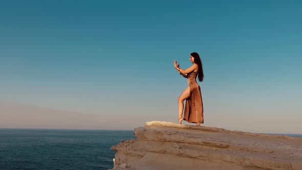 Woman Dancing on Rocks Near Sea