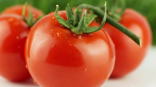 Ripe natural tomatoes close-up. Organic tomato rotating on a green background Macro shot. alt