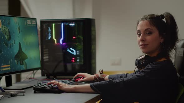 Gamer Looking at Camera Smiling Playing Online Space Shooter Video Game alt