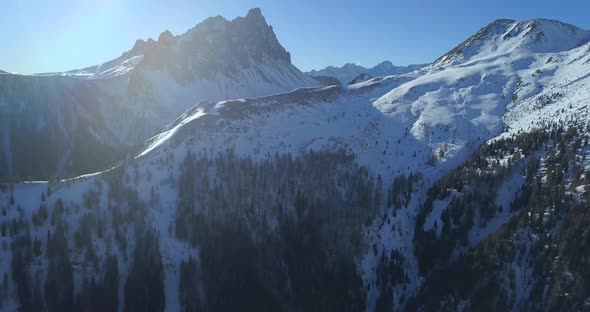 Aerial drone view of snow covered mountains in the winter alt