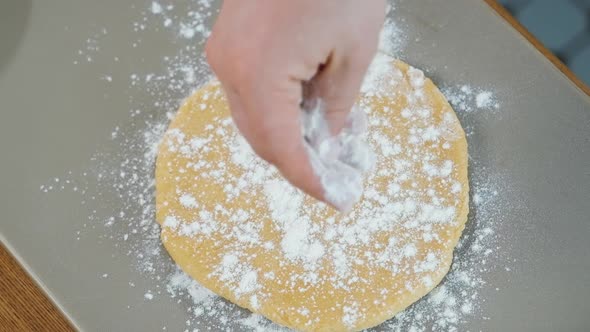 Top View Chef Sprinkles Flour on the Round Circle Piece of Dough in Bakery