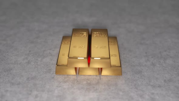 A stack of gold bar ingots on a concrete background. Gold reserves or gold standard concept.