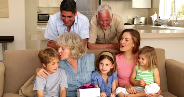 Grandmother Getting Presents from her Grandchildren on Couch alt