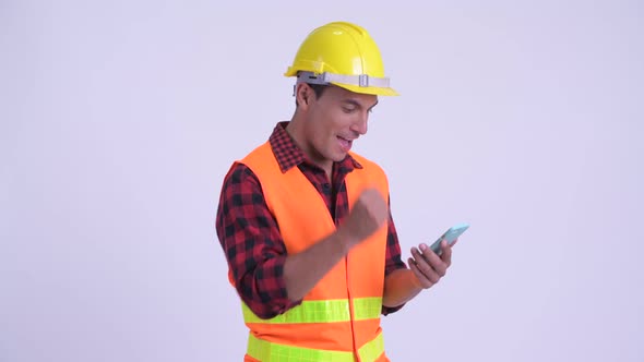 Young Happy Hispanic Man Construction Worker Using Phone and Getting Good News