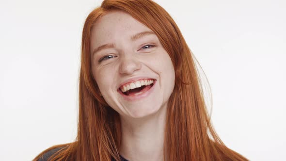 Close Footage of Young Caucasian Red Haired Teenage Girl Smiling Laughing on White Background alt