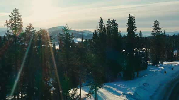 Cinematic Drone, flies forward and up, revealing snow covered Colorado mountains, lens flare