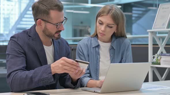 Male and Female Professionals Having Online Payment Failure on Laptop alt