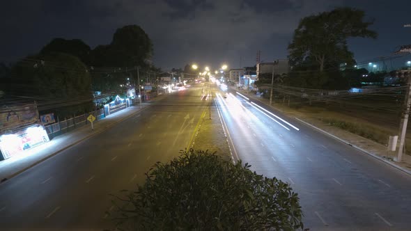 Static nightlapse of a busy highway and car trails at night from a high angle over the street. alt