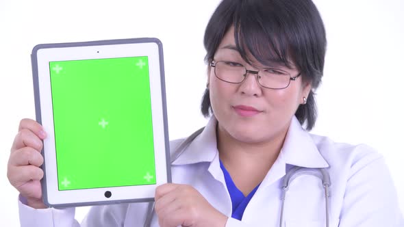 Face of Happy Overweight Asian Woman Doctor Showing Digital Tablet alt
