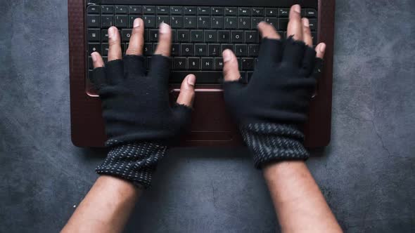 Hacker Hand Stealing Data From Laptop Top Down alt