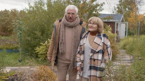 Elderly Spouses Walking in Garden alt
