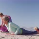 Yoga teacher teaching yoga to senior women at the beach