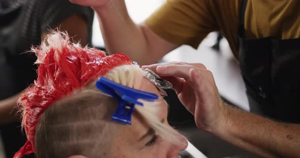 Side view woman having her hair styled by a hairdresser alt