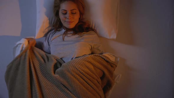 Pretty Girl Lying in Her Orthopedic Bed, Turning Off Light and Falling Asleep alt