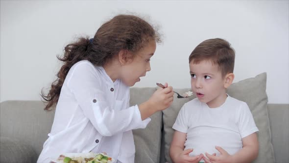 Daughter a Pretty Sister, Nanny with a Younger Brother Are Sitting on the Couch,loving Happy Sister alt