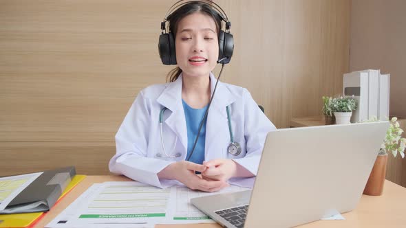 Young attractive Asian female doctor diagnosis talking and looking to camera alt