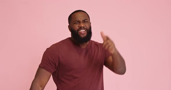 Young African American Satisfied Man Pointing with Finger Pistols Isolated on Pink Background alt