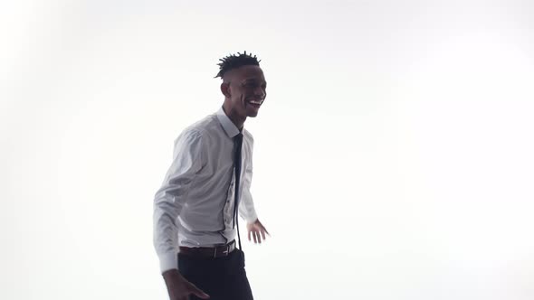 Black Man Happy and Dances in a Suit on White Background alt