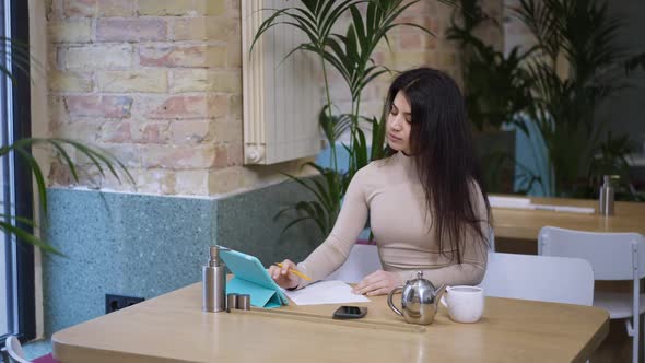 Portrait of Intelligent Middle Eastern Confident Young Businesswoman Writing Surfing Internet on alt