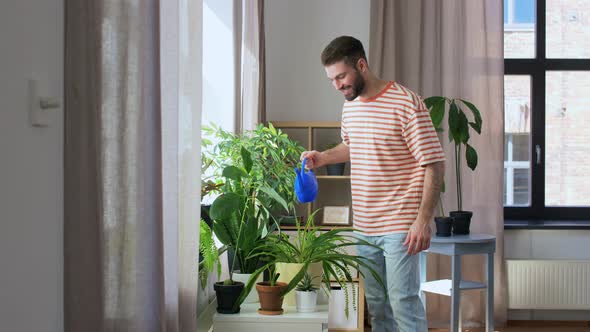 Happy Smiling Man Watering Flowers at Home