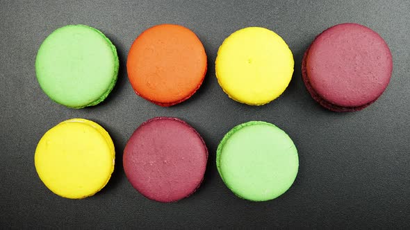 Rows of a colorful macaroons on a black table