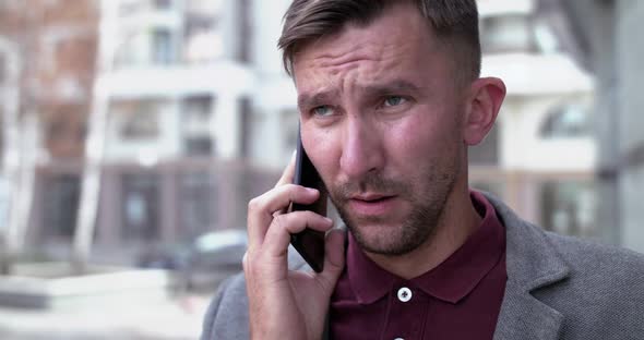 Portrait of Man Talks on the Phone and Sneezes Strongly on Street alt