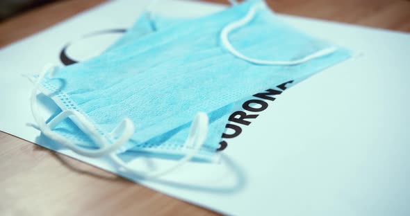 Close Spin Shot of The Top Of a Corona Document With Surgical Masks Dropping  on Top with the Bio Ha alt