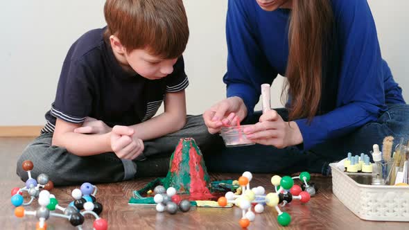 Mom and Son Make Experience with Plasticine Volcano at Home