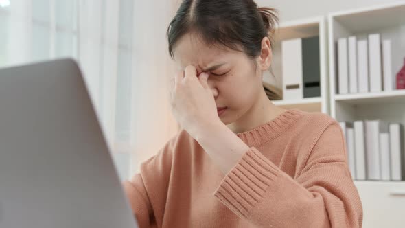 woman using laptop and feeling eye strain at home office after long working on computer alt
