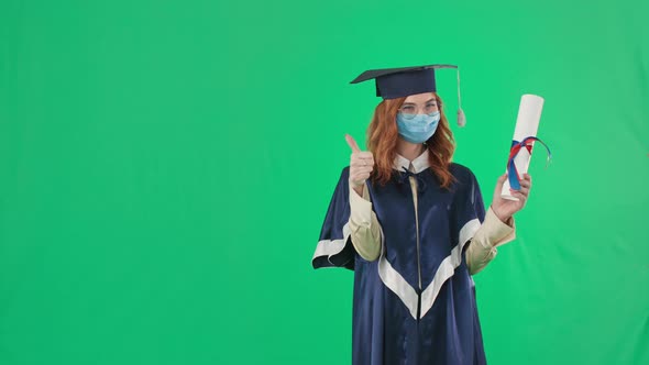 Education in Quarantine Graduate in Academic Clothes and Medical Mask Shows Diploma with Her Finger