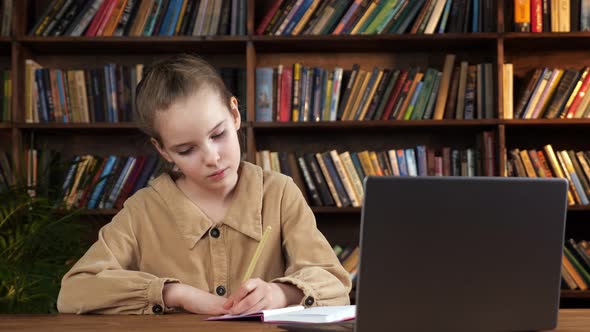 Young Student in Brown Jacket Writes Lecture Into Notebook alt