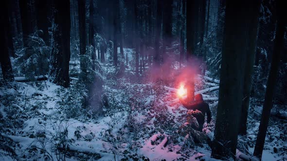 Man Lights Flare And Walks Through Snowy Forest alt