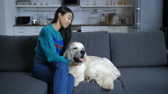 Young Indian Woman Talking To Dog at Home alt
