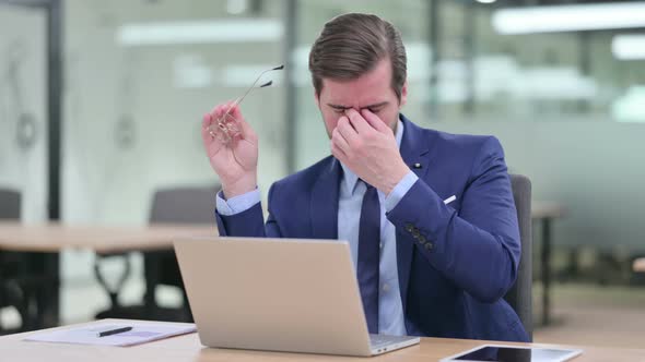 Stressed Young Businessman with Laptop Having Headache  alt