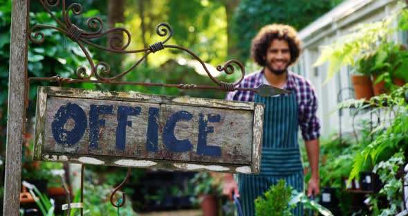 Gardener walking near office signboard alt