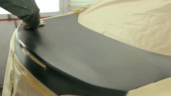 Mechanic Seals the Machine with Protective Paper Before Painting the Rear Hood alt