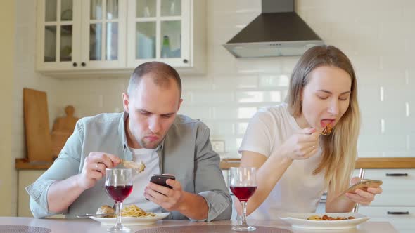 Couple at Breakfast Table Using Mobile Phone alt
