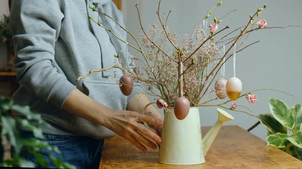 Woman Decorating DIY Easter Floral Arrangement alt