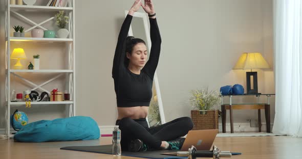 Wide Shot Portrait of Beautiful Young Yogi Sitting in Lotus Pose and Doing Breathing Exercises Using alt