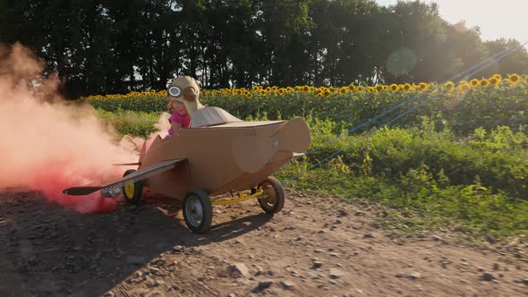 Smiling Little Girl Driving a Cardboard Plane with Smoke Bombs alt
