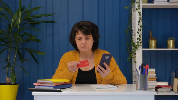 Middle Aged Woman Online Shopping at Home on Smartphone Typing Credit Card Number and Cancel