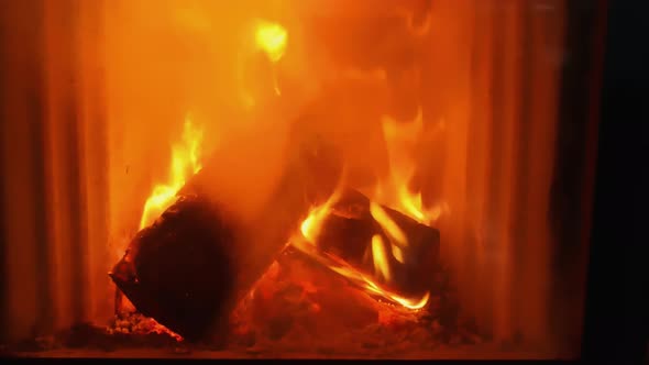 Background with firewood burning in the fireplace, flames and fire at night. alt