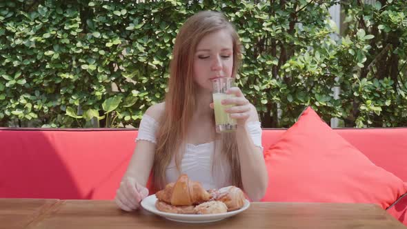 Young Woman Eat Breakfast or Lunch in Restaurant with Croissant Pastry Juice alt