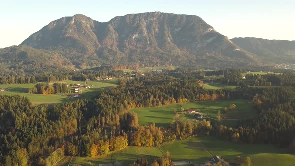 Aerial view of green meadows with villages and forest in austrian Alps mountains. alt